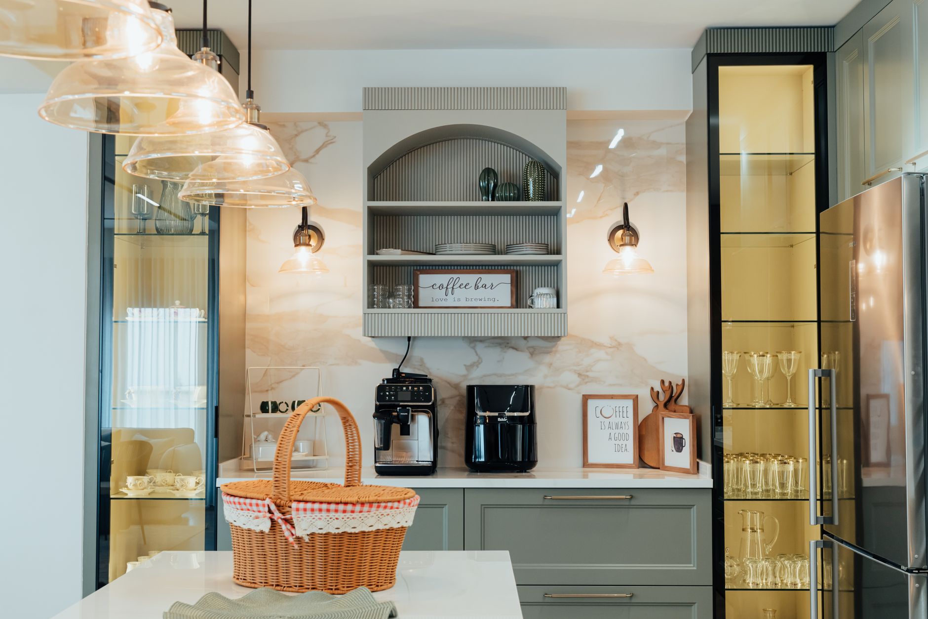 Elegant modern kitchen featuring a coffee bar, glass cabinets, and stylish lighting for a warm ambiance.