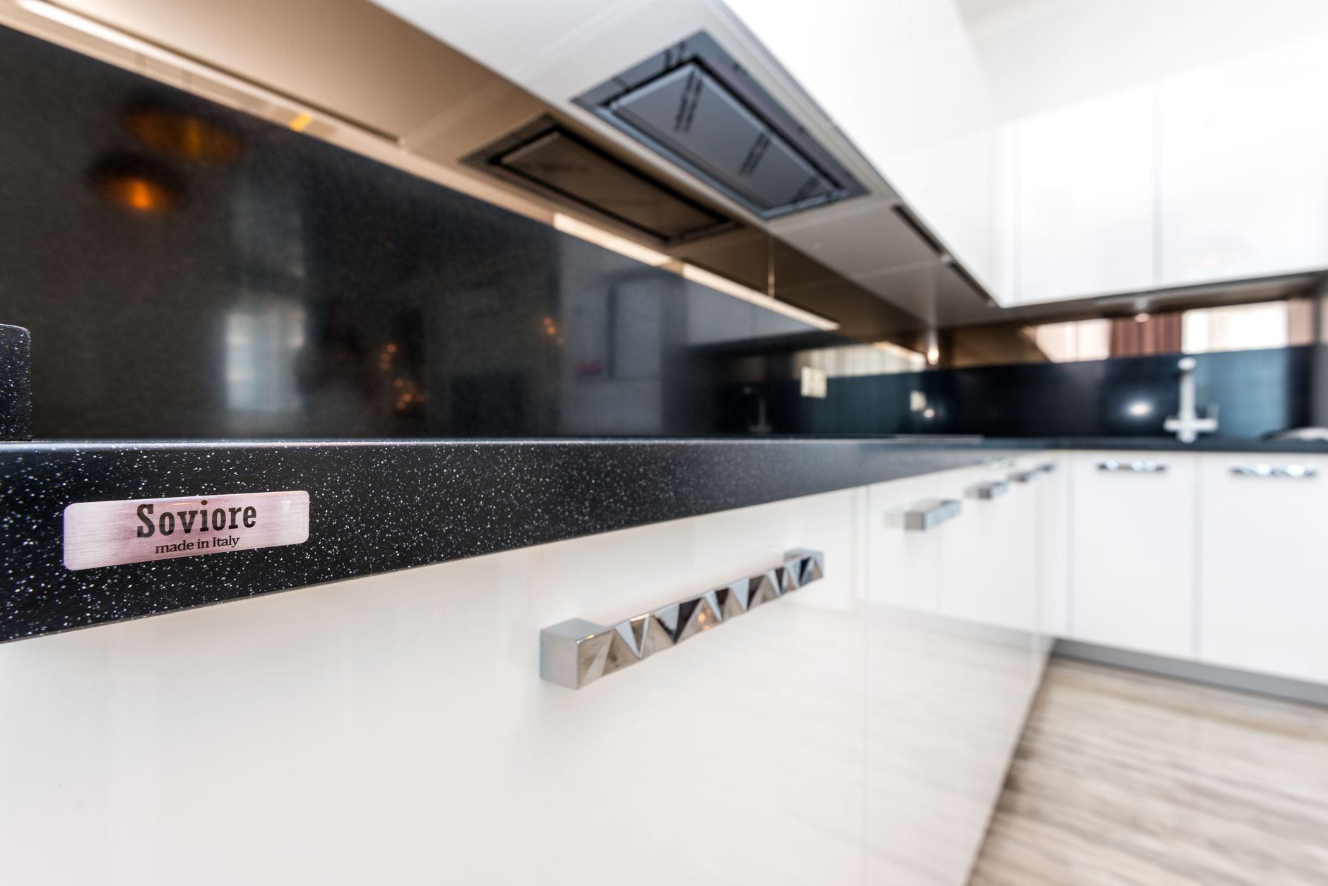 Sleek modern kitchen design featuring white cabinets and Soviore brand details.