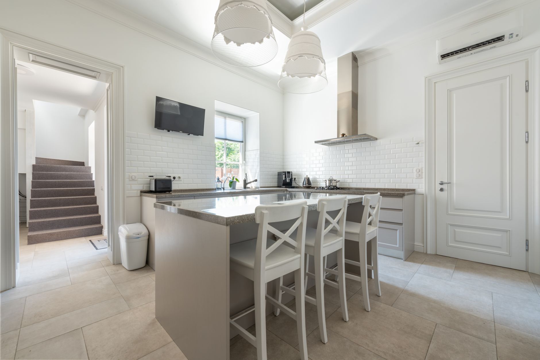 Bright modern kitchen with island, bar stools, and stylish decor.