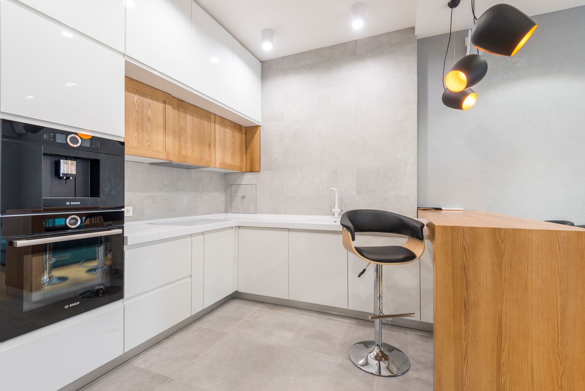 Interior of modern spacious kitchen with wooden furniture and oven and with many lamps